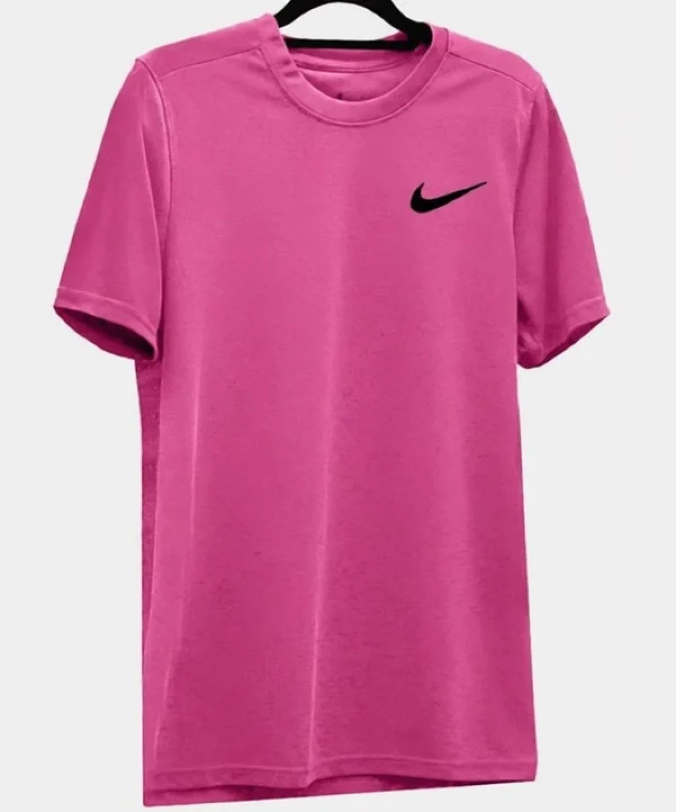 Pink Nike t-shirt hanging on a black hanger against a light background