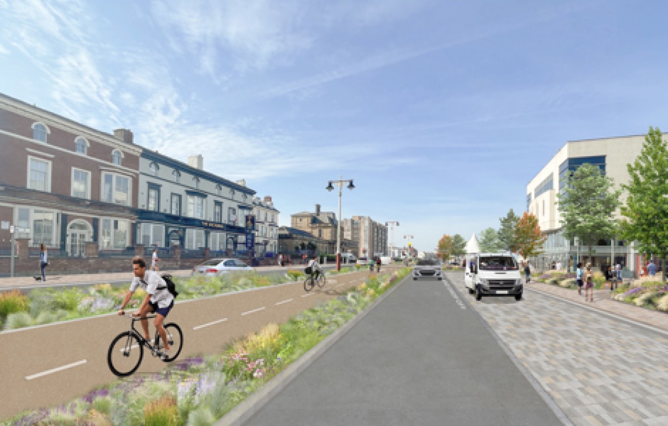 Bright street scene with cyclists on a dedicated bike lane and pedestrians on the pavement.