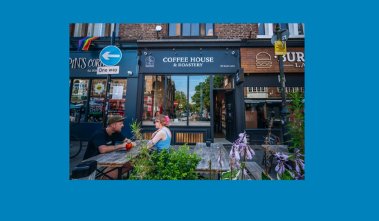 Outdoor café seating in front of a coffee house on a city street
