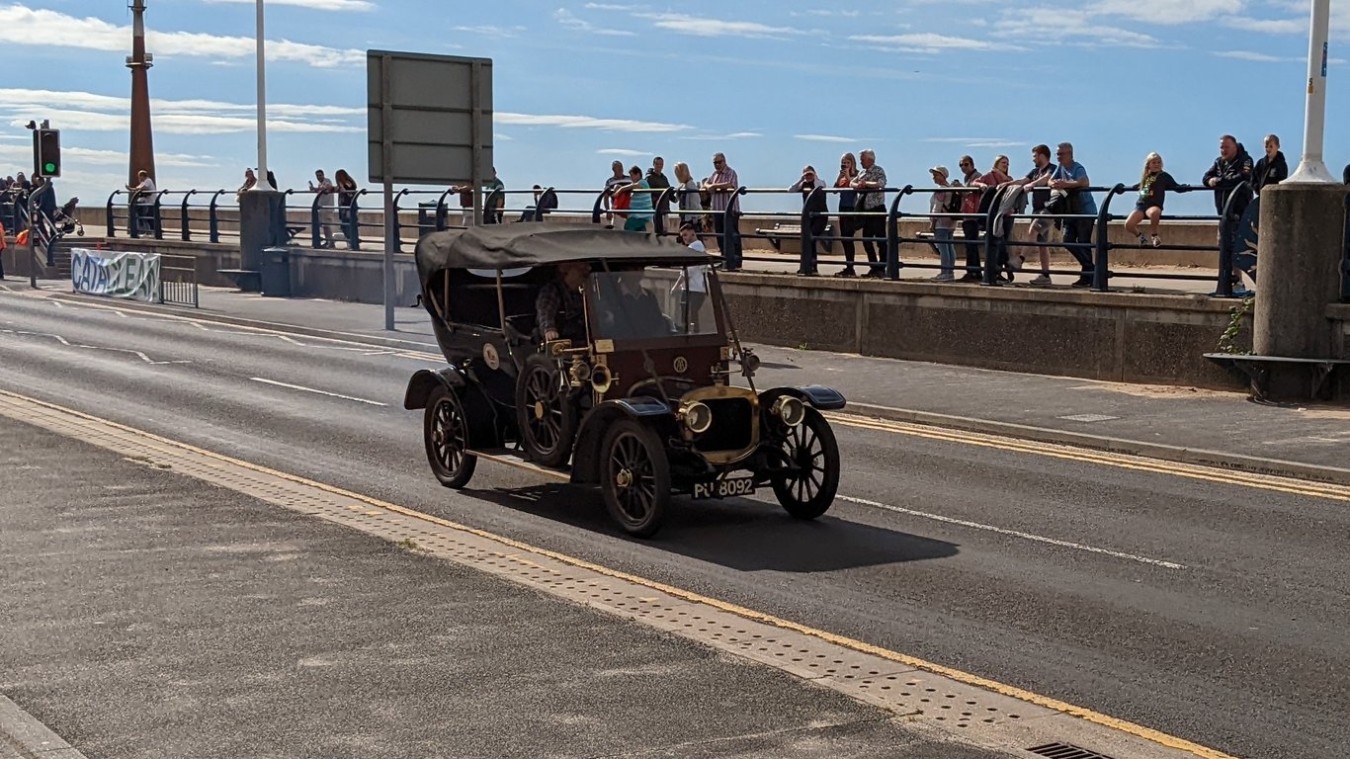 Classic car driving down coast road in Southport