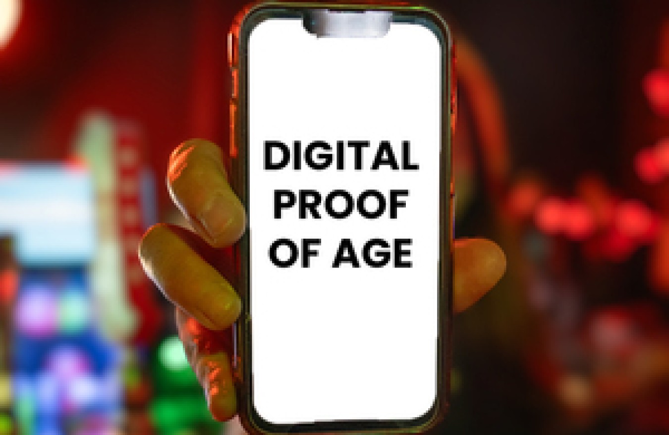 Person holding a smartphone showing the words DIGITAL PROOF OF AGE on screen