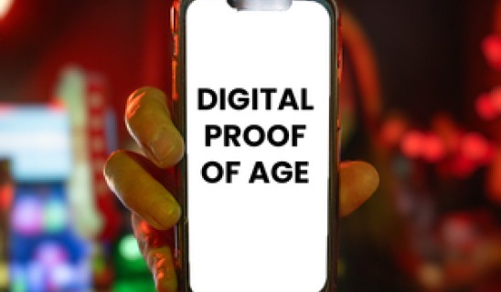 Person holding a smartphone showing the words DIGITAL PROOF OF AGE on screen