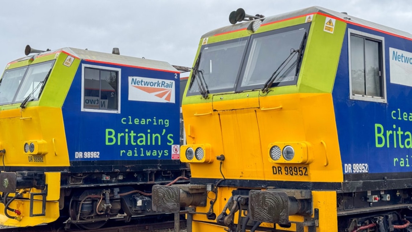 Two bright Network Rail diesel locomotives painted in blue and yellow parked side by side