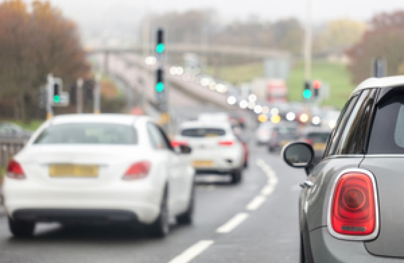 Urban road with cars in traffic and traffic lights ahead