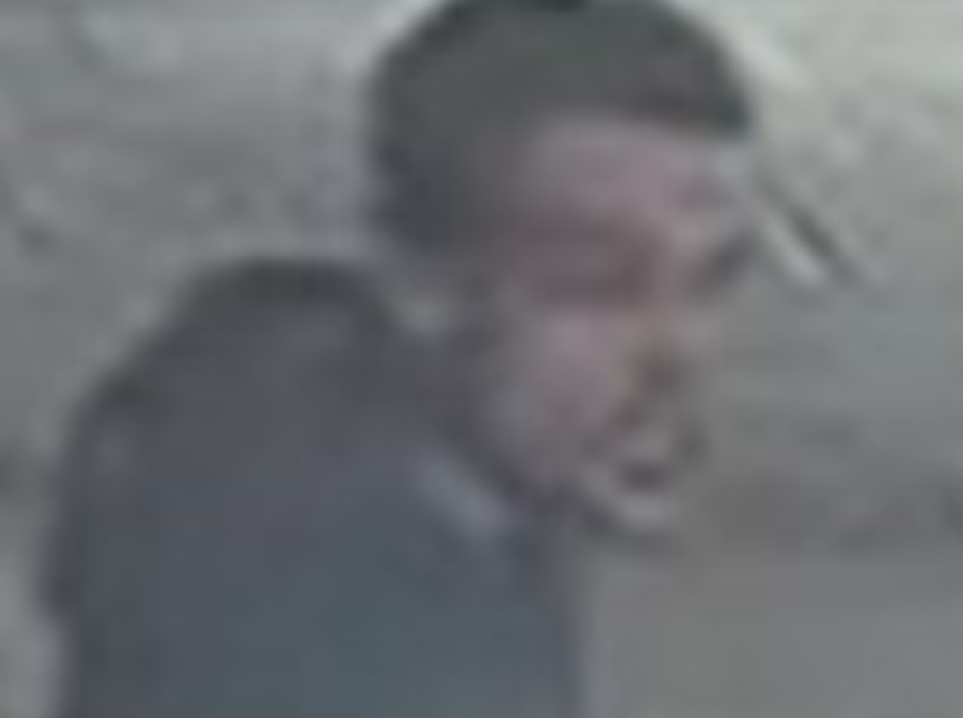 Blurred man walking outdoors, indistinct features visible