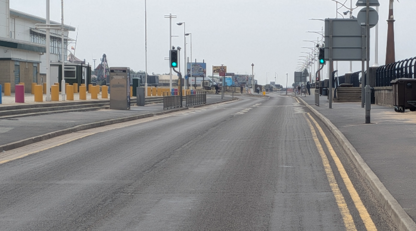 Empty road near a harbour with traffic lights and jetty barriers on both sides