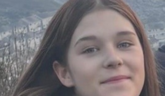 Young woman's face in close-up with hillside background