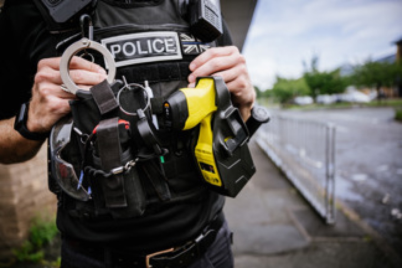 Close-up of a police officer's tactical vest and equipment by a waterfront