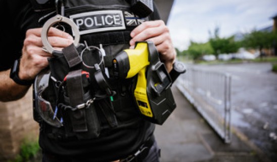 Close-up of a police officer's tactical vest and equipment by a waterfront