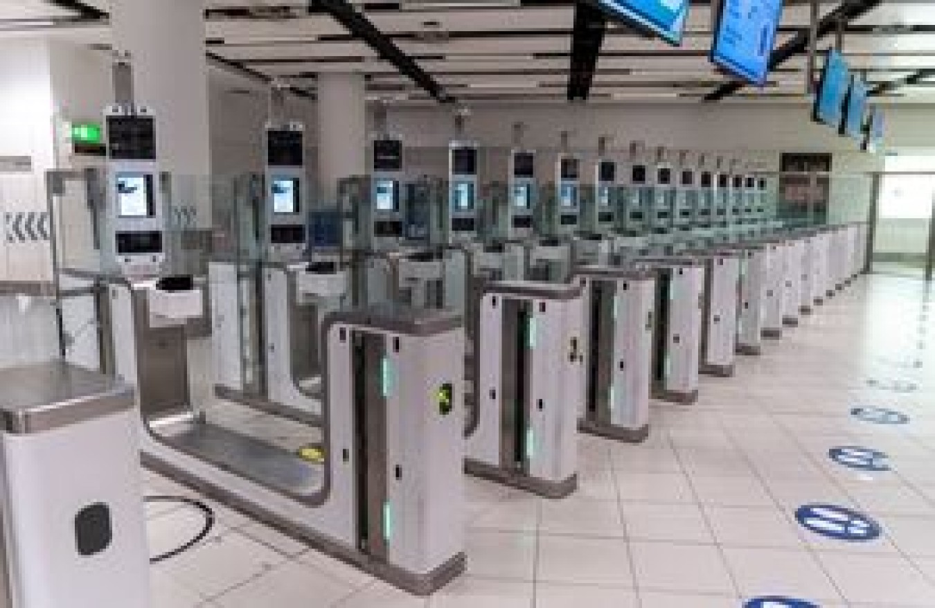Turnstiles in a modern transit station with ticket barriers and digital screens