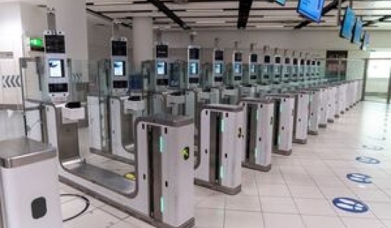 Turnstiles in a modern transit station with ticket barriers and digital screens